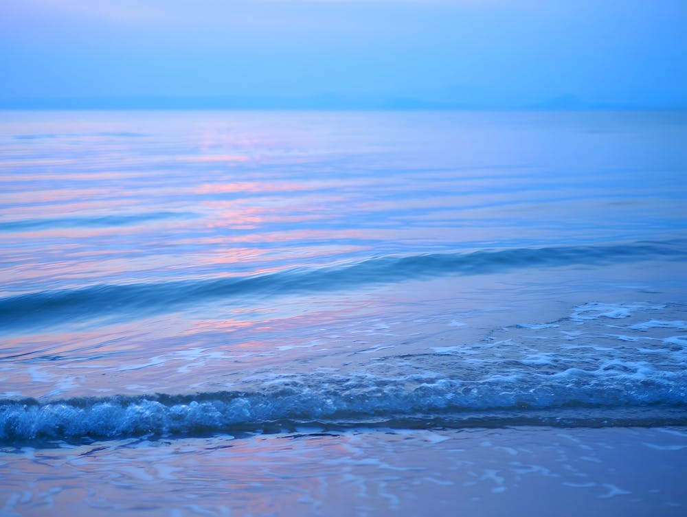 Calm Coastal Sunset: Serene Blue Tones Reflecting on the Water