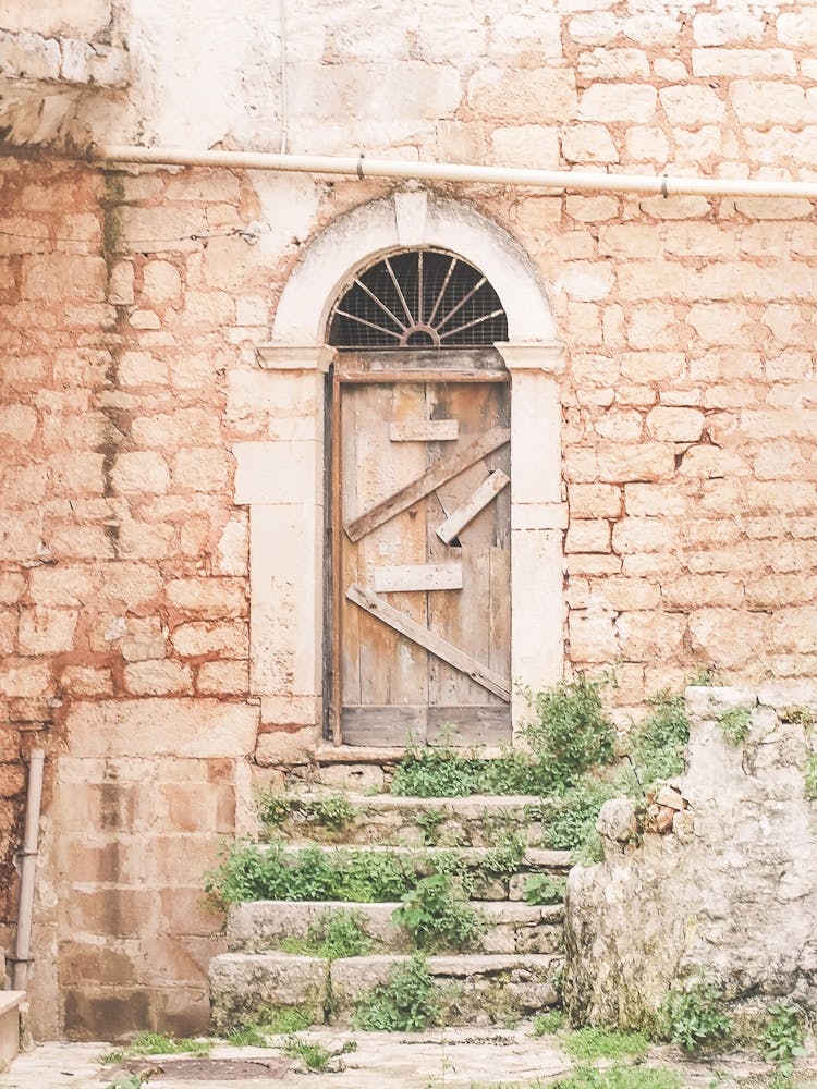 Puglia, Italy I Forbidden door in abandoned destroy wood of authentic architectural urbex building photography to the retro vintage pastel orange aesthetic of a Mediterranean countryside village in Baroque period