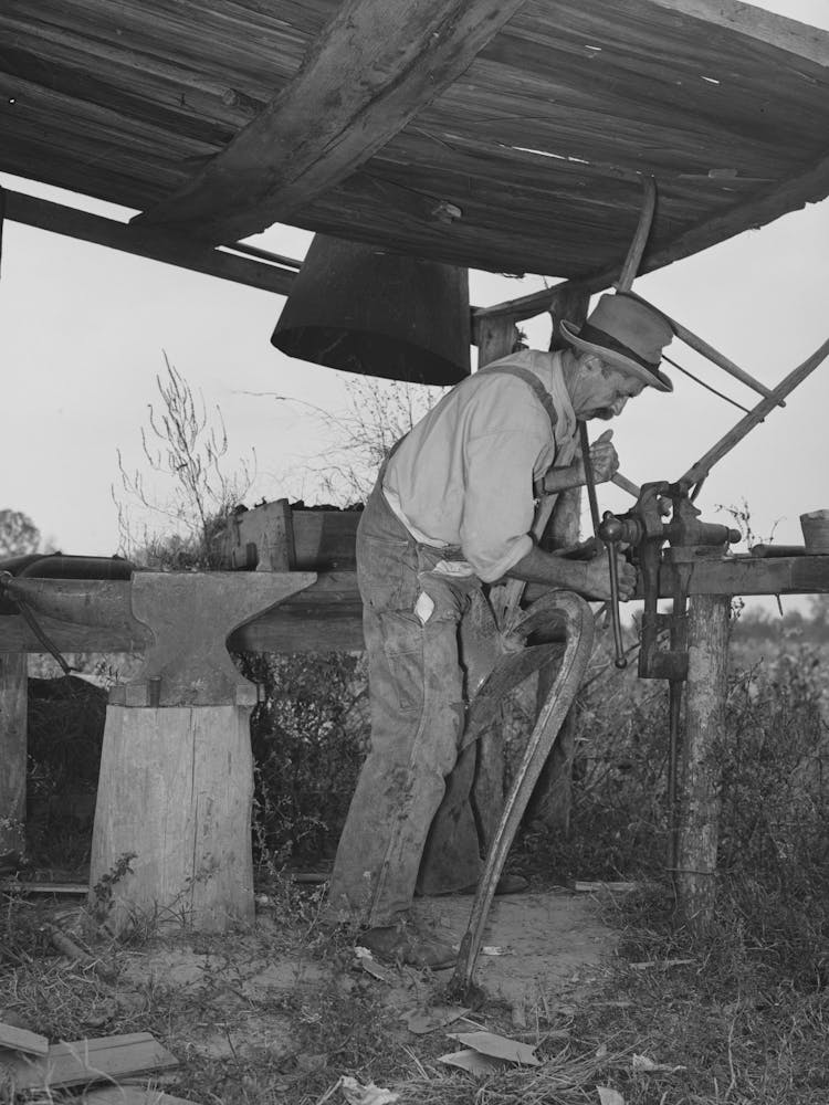 W E Smith, Farmer Near Morganza, Louisiana, Doing Smith Work On Plow In His Improvised Blacksmith Shop By