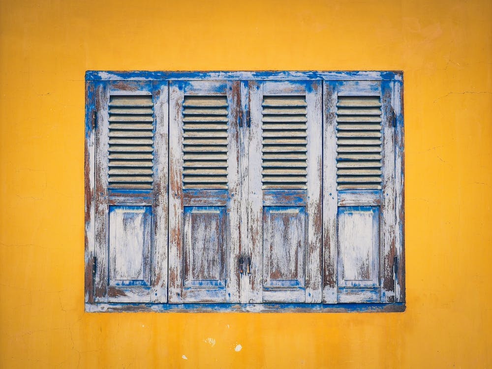 Weather Worn Shutters Yellow Painted Wall