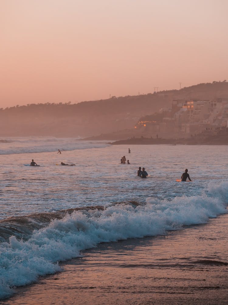 Surfers during sunset in the surftown of Taghazout, Morocco