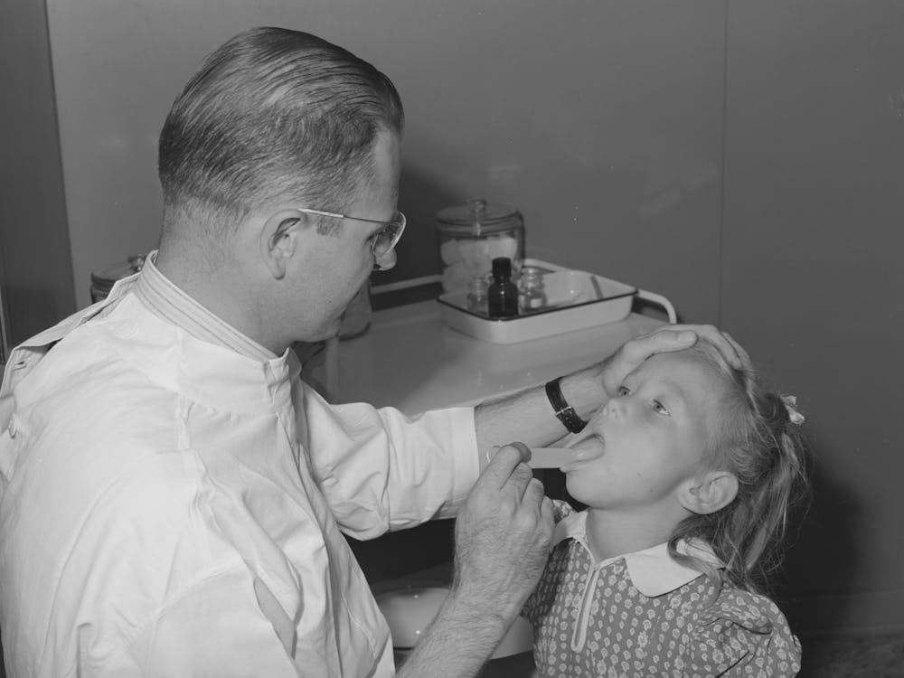 Doctor Examines Daughter Of Farm Worker Living At The Fsa (Farm Security Administration) Labor Camp, Caldwell,