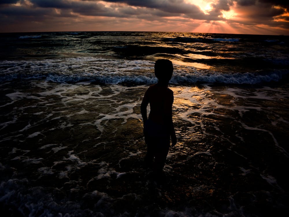Young Boy Looking At The Sunset