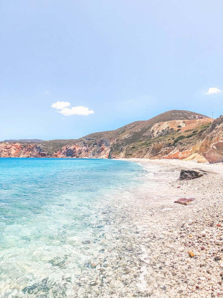 Milos, Greece I Dreamy desert beach paradise in the mountains with red aesthetic and turquoise water for the wild boho nature summer landscape photography typical of Cyclades islands like Santorini and Mykonos