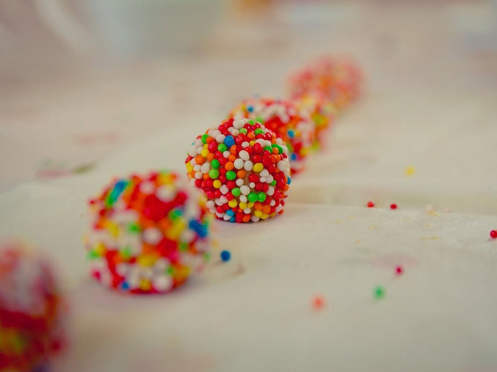 Close Up On White Chocolate Balls Covered With Candies Arranged In A Row