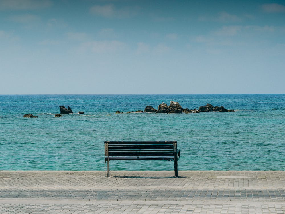 Empty Bench On The Beach