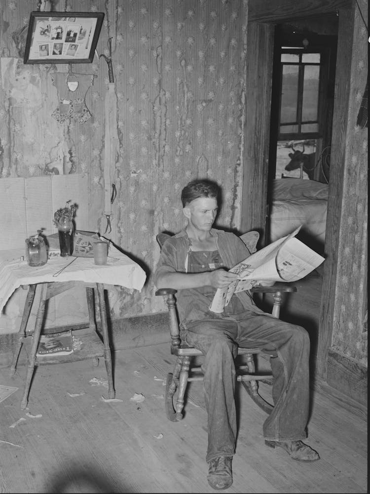Son Of Tenant Farmer Reading The Morning Paper While Waiting For Noonday Meal Near Muskogee, Oklahoma