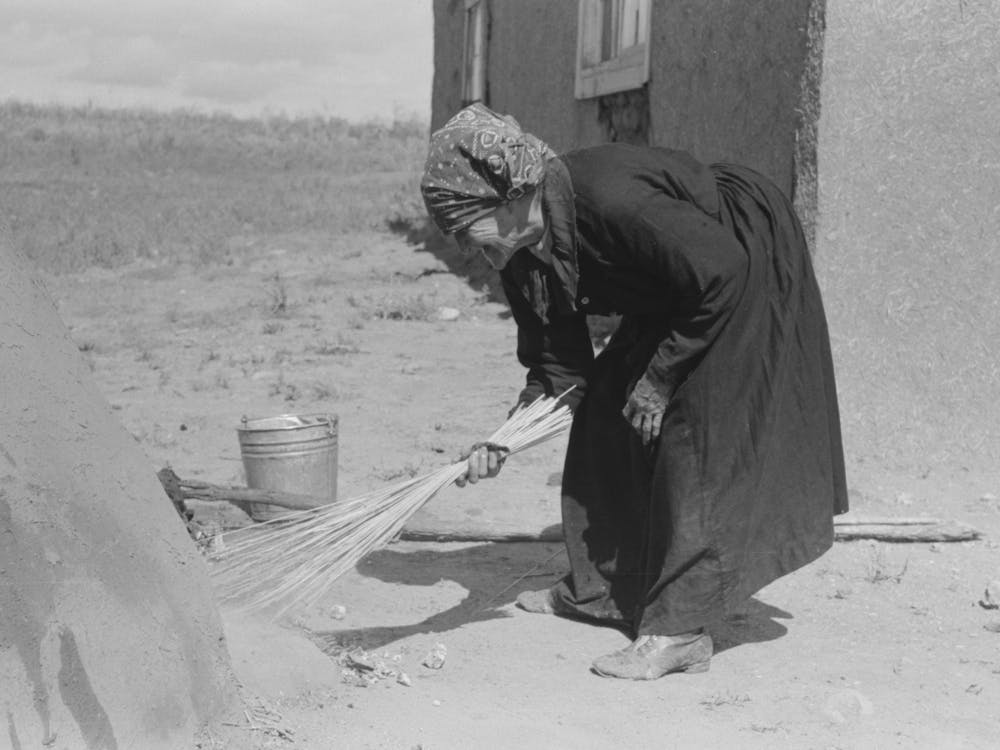 Sweeping Hot Coals From Outdoor Earthen Oven After It Has Been Heated To Proper Temperature To Bake Bread