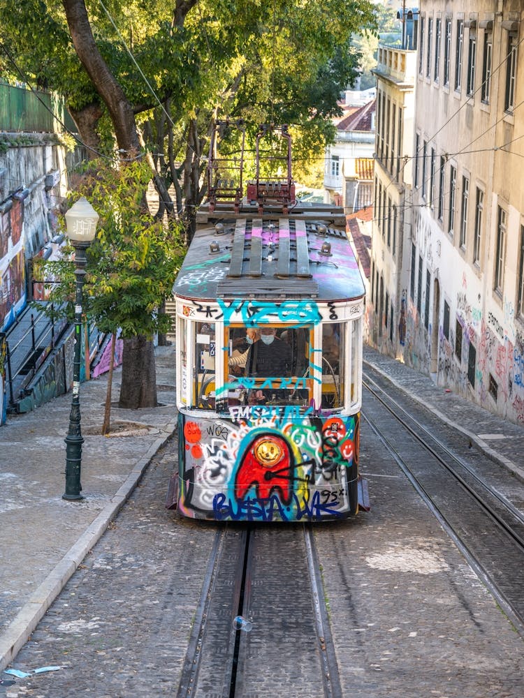 A streetcar sprayed with graffiti in Bairo Alto in Lisbon - summer street and travel photography by Christa Stroo