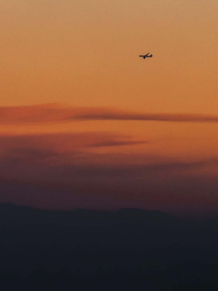 Airplane In The Sky At Sunset