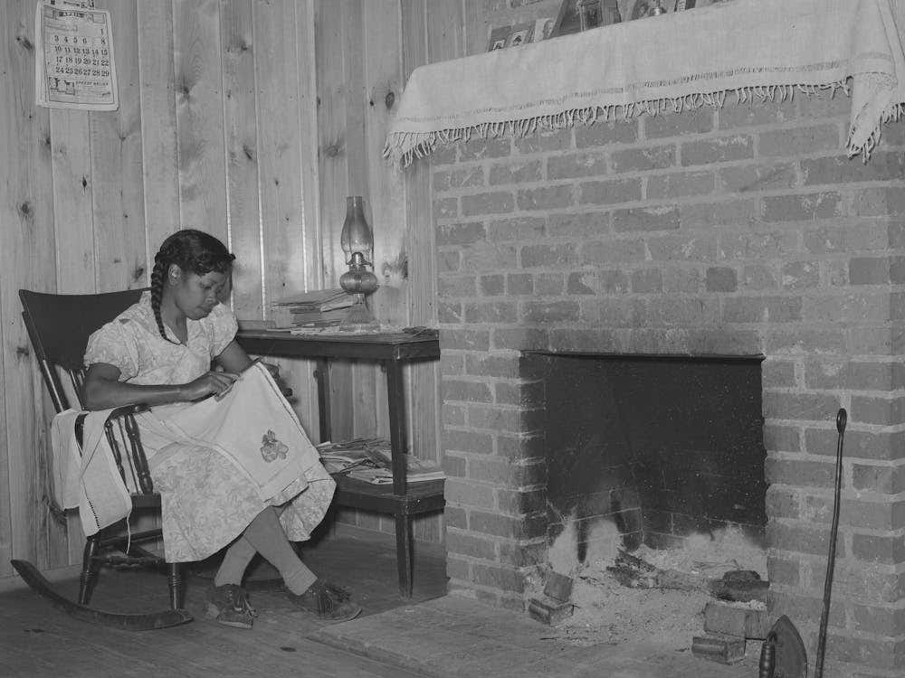 Wife Of Fsa (Farm Security Administration) Client Sewing In Front Of Fireplace In Her Home On Sabine Farms