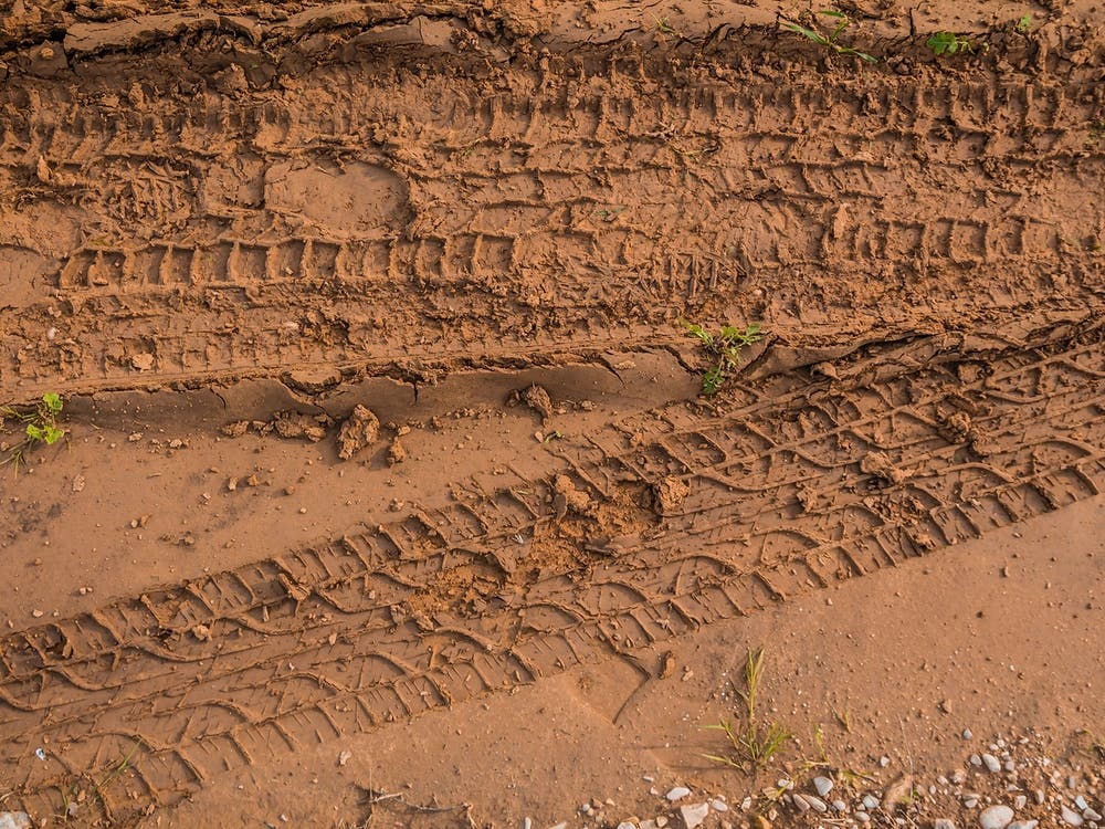 Texture Of Wet Brown Mud With Car Tyre Tracks And Shoe Footprint 2
