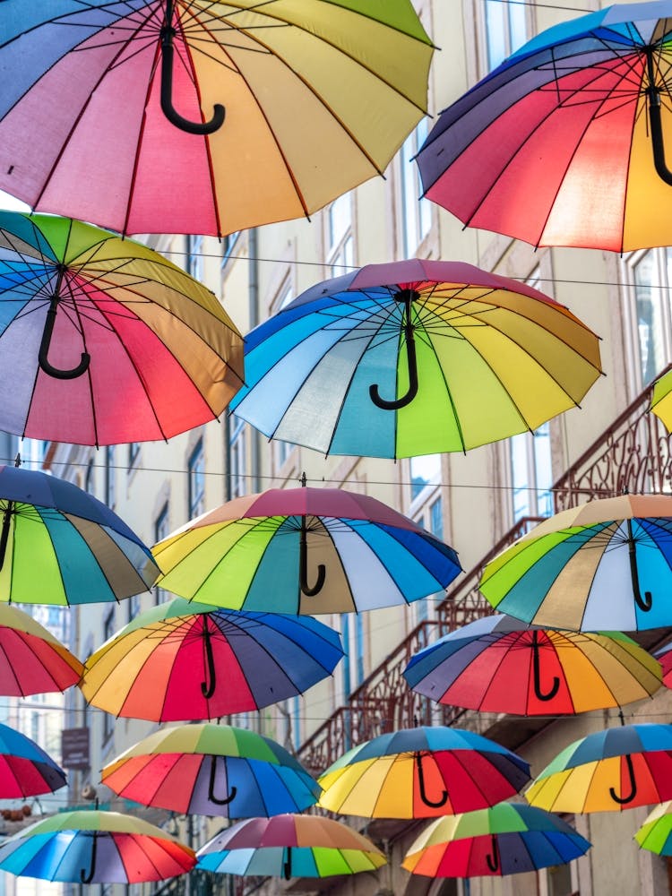 Parapluies lumineux et joyeux à Lisbonne, Portugal - photographie de rue et de voyage aux couleurs arc-en-ciel estivales par Christa Stroo Photography