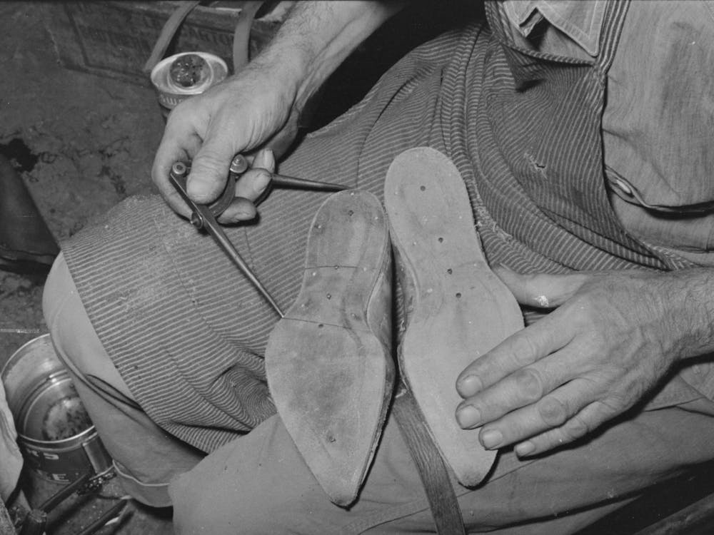 Calipering Inner Sole Of Boot To See If It Matches Pattern, Boot Shop, Alpine, Texas By Russell Lee