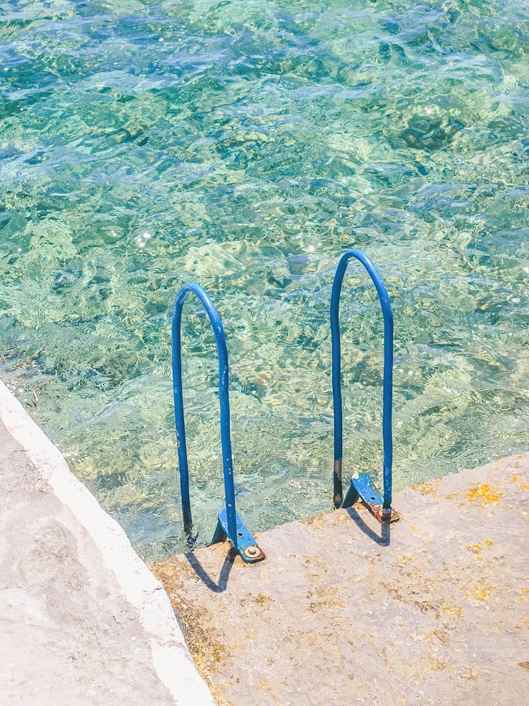 Milos, Greece I The minimalist blue swimming pool of Mediterranean sea like a paradise beach in the Cyclades to vintage pastel summer aesthetic photography of french riviera landscape and its transparent turquoise water