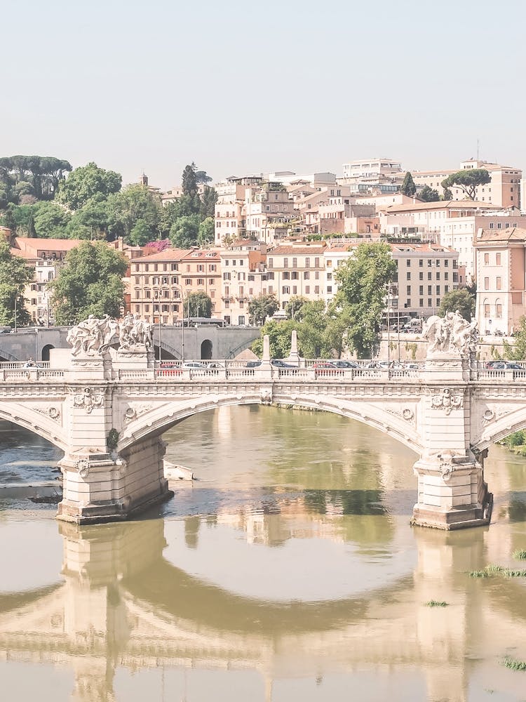 Rome, Italy I Vittorio Emanuele bridge crossing the Tiber river with pastel aesthetic cityscape and lush greenery photography in the warm summer light of la dolce vita with Mediterranean charm