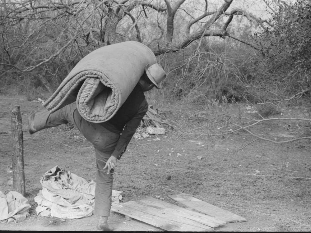 White Migrant Carrying Mattress Across Fence Near Harlingen, Texas By Russell Lee