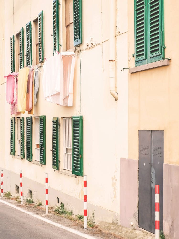 Florence, Italy I Street photography in pastel yellow summer colors in Fiesole village in Tuscany with its laundry drying in the window like la dolce vita of italian everyday daily life scene