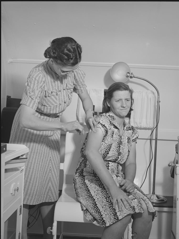 Nurse Administers Hypodermic To Wife Of Farm Worker Who Lives At The Fsa (Farm Security Administration) Migratory Lab