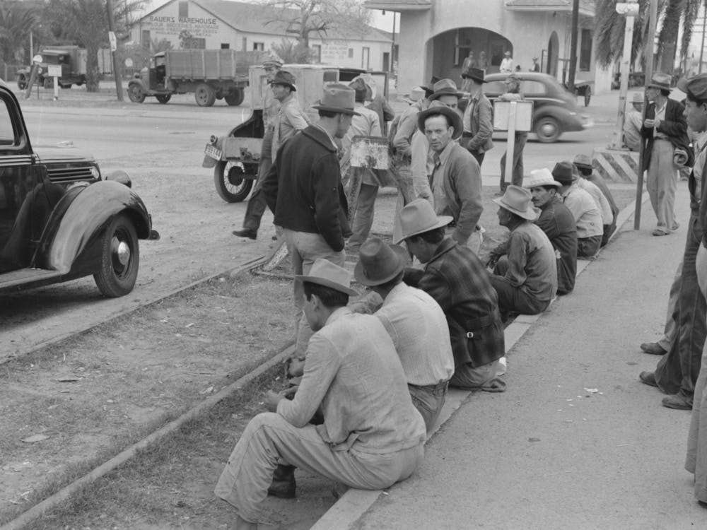 Men Sitting Along Railroad Platform Waiting For Work As Day Laborers, Raymondville, Texas By Russell Lee
