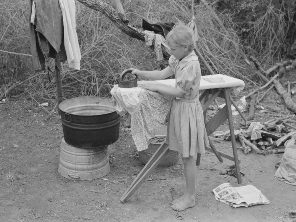 Child Of White Migrant Worker Ironing In Camp Near Harlingen, Texas By Russell Lee