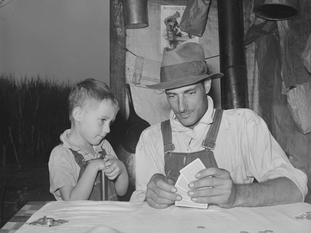 Tagelöhner mit Sohn spielen Penny Ante Poker, er ist Arbeiter auf den Zuckerrohrfeldern nahe New Iberia, Louisiana von Russell
