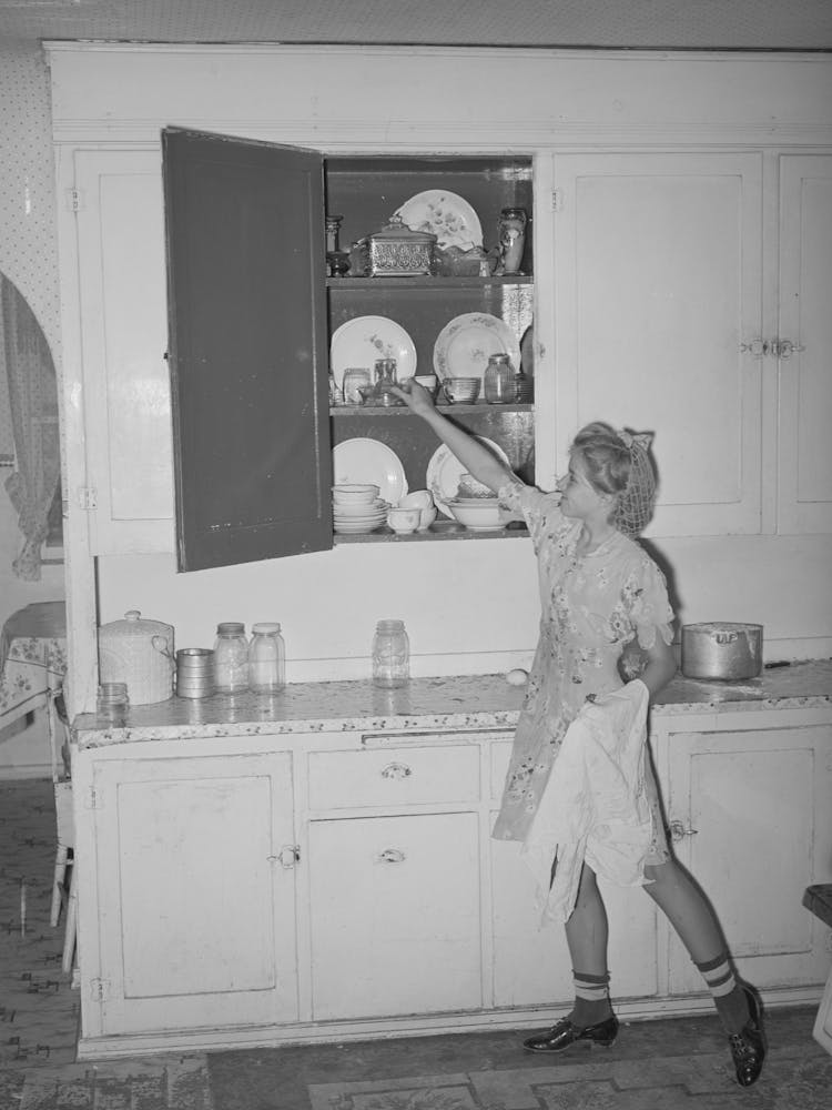 Untitled Photo, Possibly Related To Daughter Of Morman I E Mormon Farmer Putting Away Dishes In Kitchen