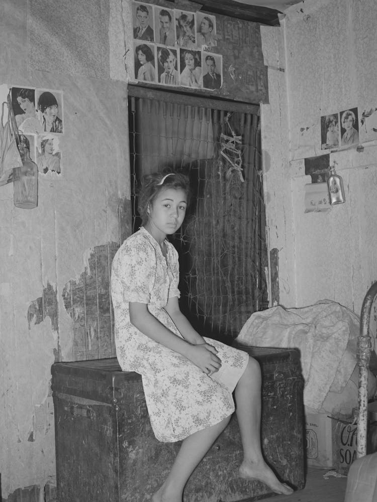 Mexican Girl Sitting In Front Of Bedspring Which Formed Partition Between The Family S Living Quarters And Those Of A