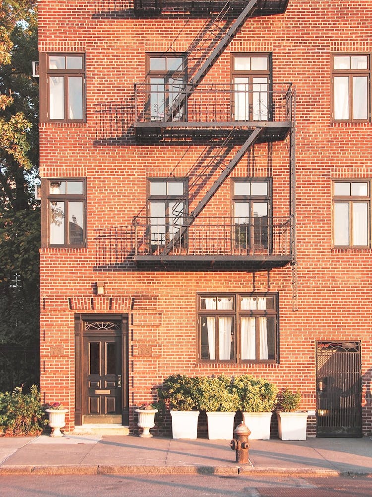New York, USA I Red brick architecture in Brooklyn with an orange autumn aesthetic in a minimalist retro vintage photography style in arty Williamsburg overlooking the Hudson River with the light of the sunset