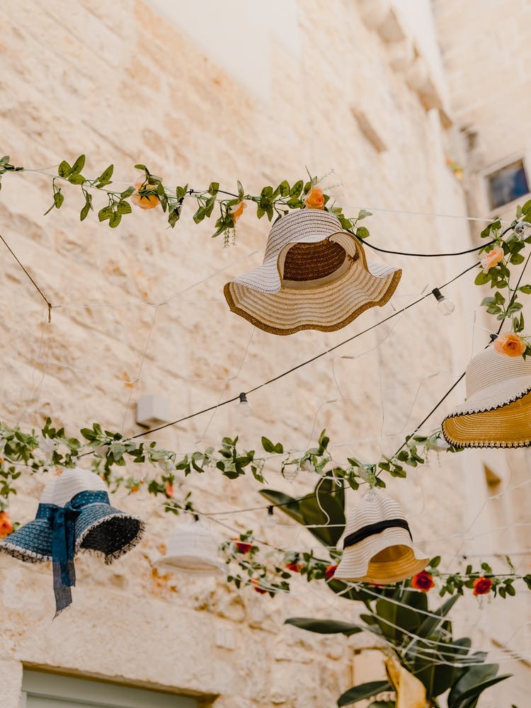 Hats And Flowers hanging in the streets in Puglia, Italy | travel photography
