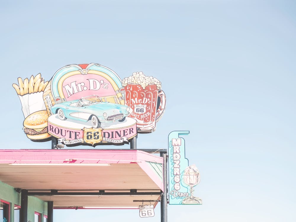 Route 66, USA I Retro vintage neon sign for 50s American diner Mr D'z in pastel pink, blue aesthetic photography with a vintage car fries, burger and beer as an illustration drawing art in Arizona or California