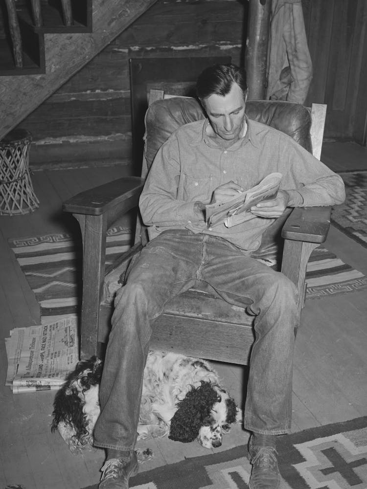Manager Of The Navajo Lodge Working A Crossword Puzzle With His Dog At His Feet Datil, New Mexico By Russell Lee