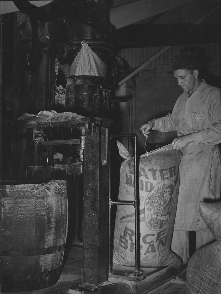 Sewing Bag Of Rice Brand After Being Weighed In Rice Packaging Process,Crowley, Louisiana By Russell Lee 1