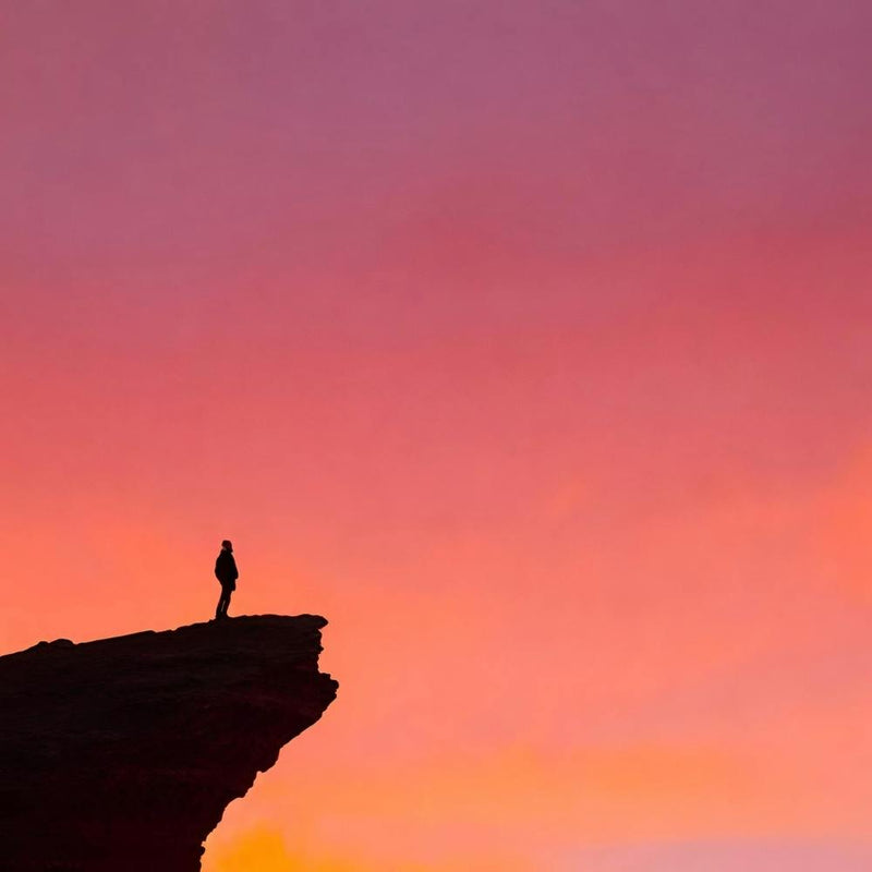 Silhouette eines Mannes auf einer Klippe stehend