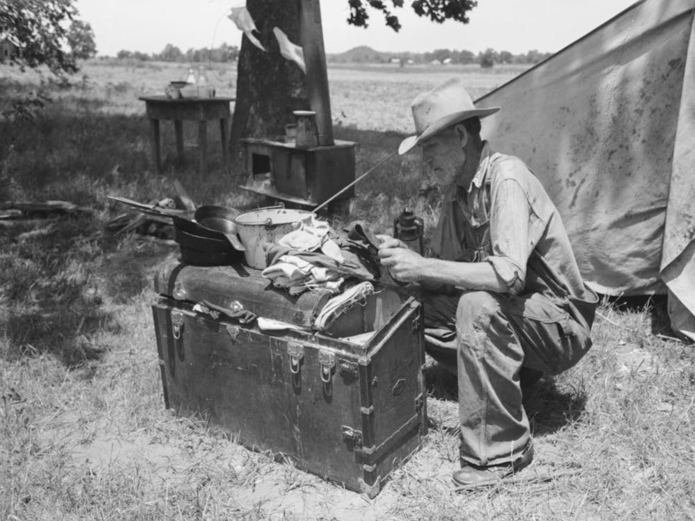 Veteran Migrant Agricultural Worker Examining Contents Of His Trunk, Camped On Arkansas River In Wagoner County