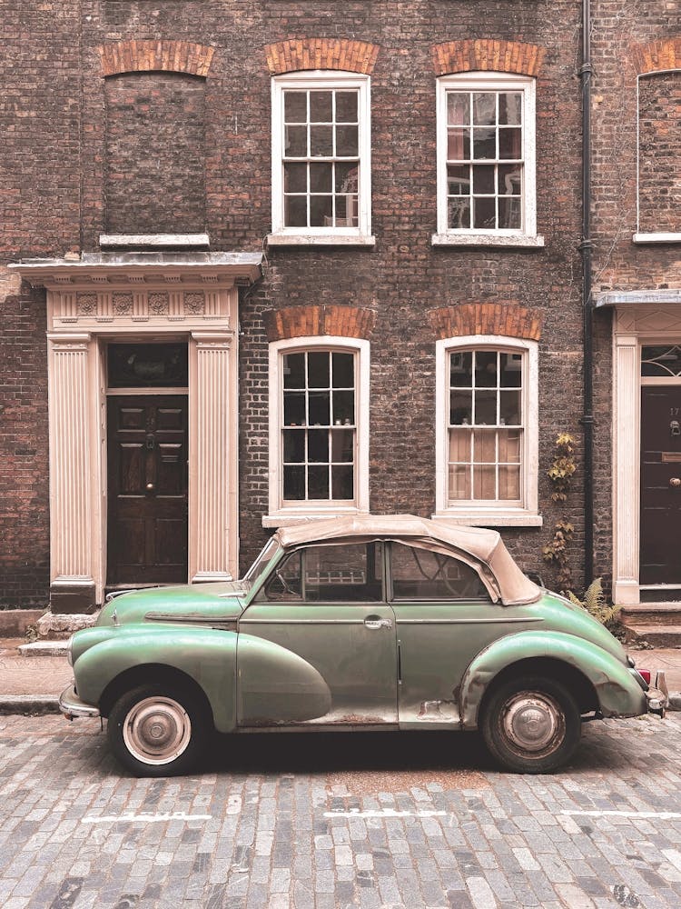 London, England I Vintage retro car on a street with urban industrial architecture and brick facade with the nostalgic aesthetic photography of a picturesque authentic British street urban city landscape