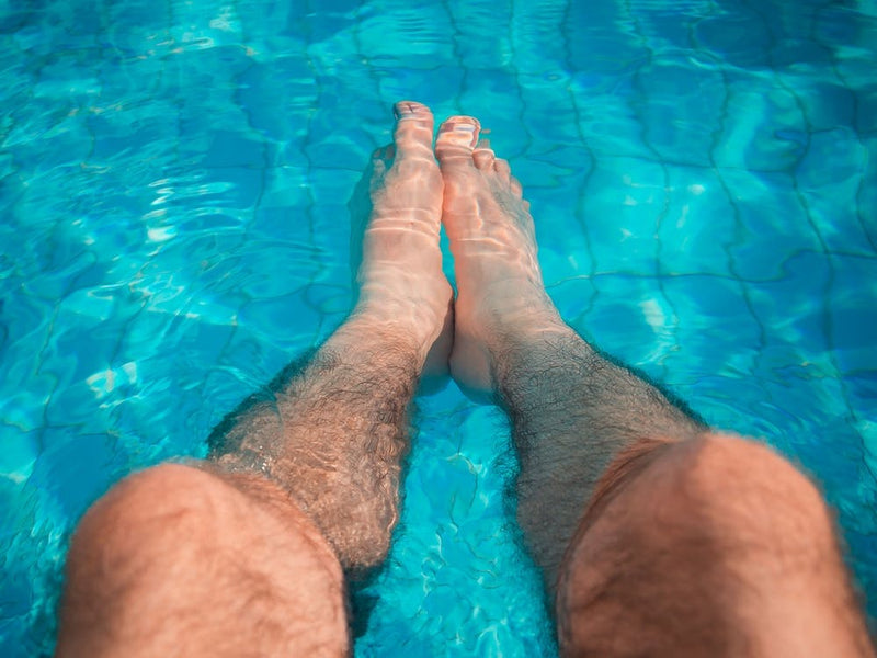 Young Man Relaxation At The Swimming Pool With His Legs In The Water