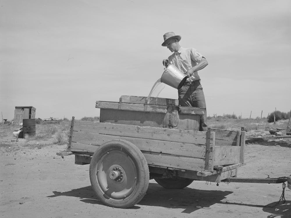 Filling A Tank Full Of Water To Take To The School House, School Was Just About To Open When This Picture Was Taken In