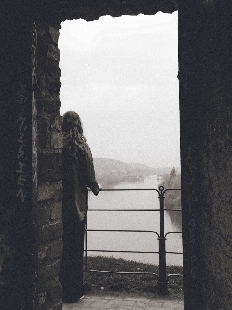Woman Looking Out A Window in Prague