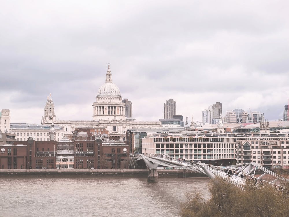 London, England I Skyline view of Saint Paul's Cathedral Millennium Bridge over River Thames from the Tate Modern museum for a grey urban landscape panorama photography in the Londoner rain
