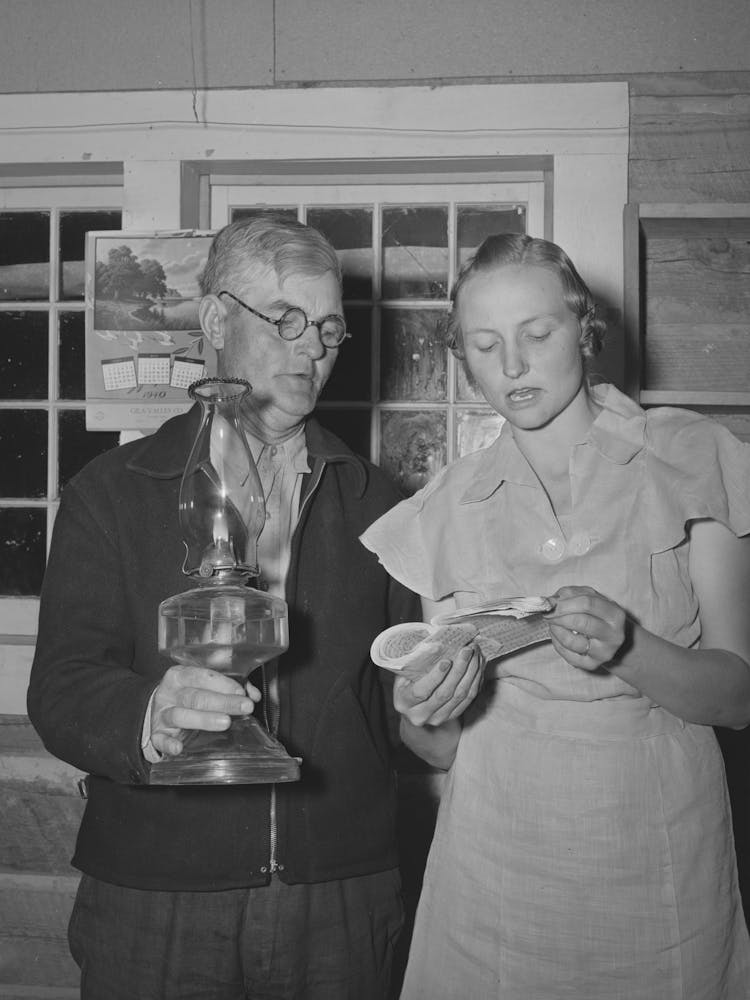 Mr, Besson, President Of The Literary Society Holds The Lamp For Mrs, Caudill, Secretary, During A Song At The Literary