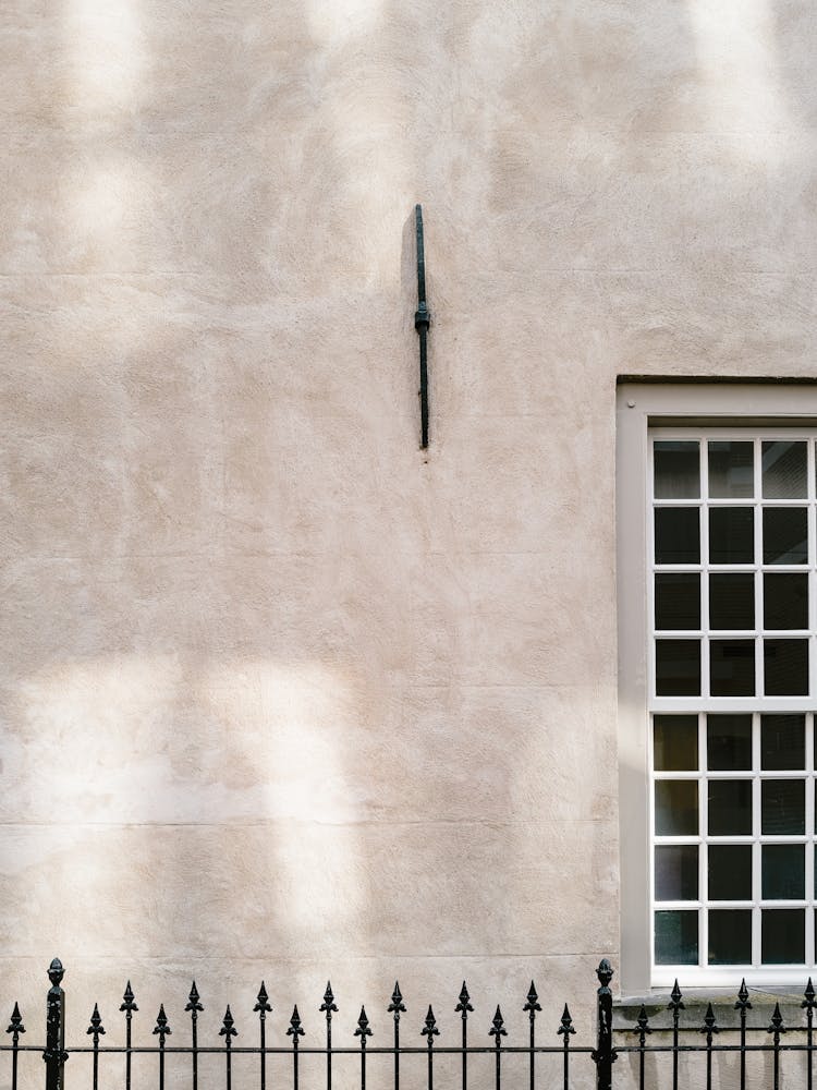 Shadow On The Wall With A Window And A Fence