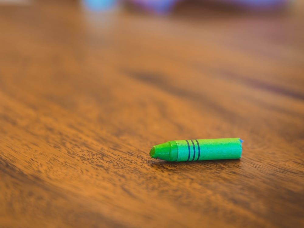 Green Color Pastel Crayon On Brown Wooden Table