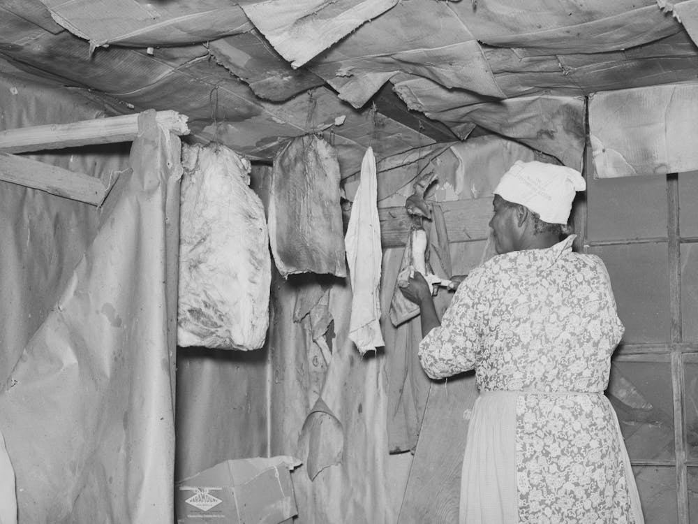 Southeast Missouri Farms, Wife Of Sharecropper Cutting Piece Of Fatback From Slab In Kitchen Of Shack Home By