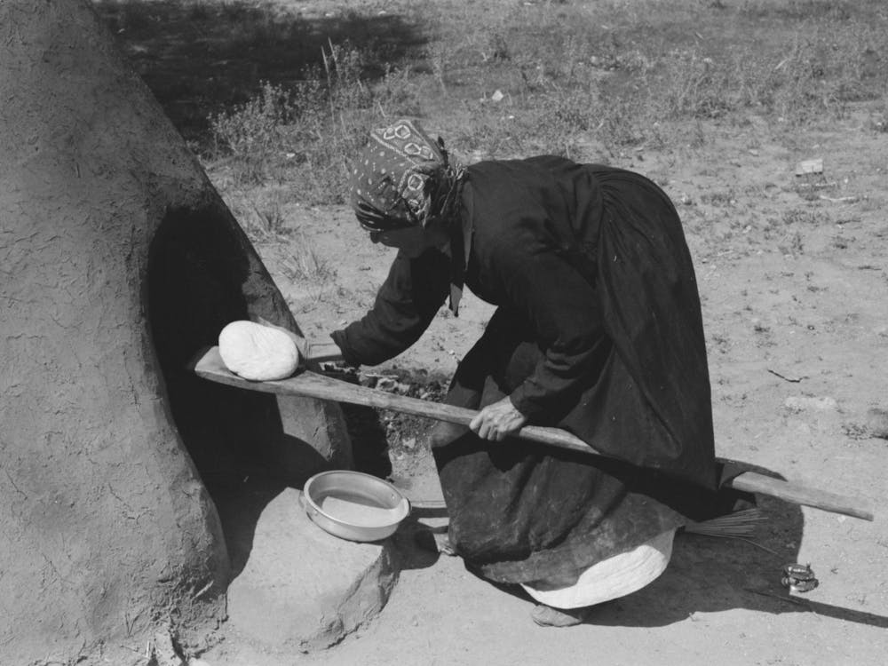 Spanish American Woman Putting Loaf Of Bread Into Oven, Taos County, New Mexico By Russell Lee