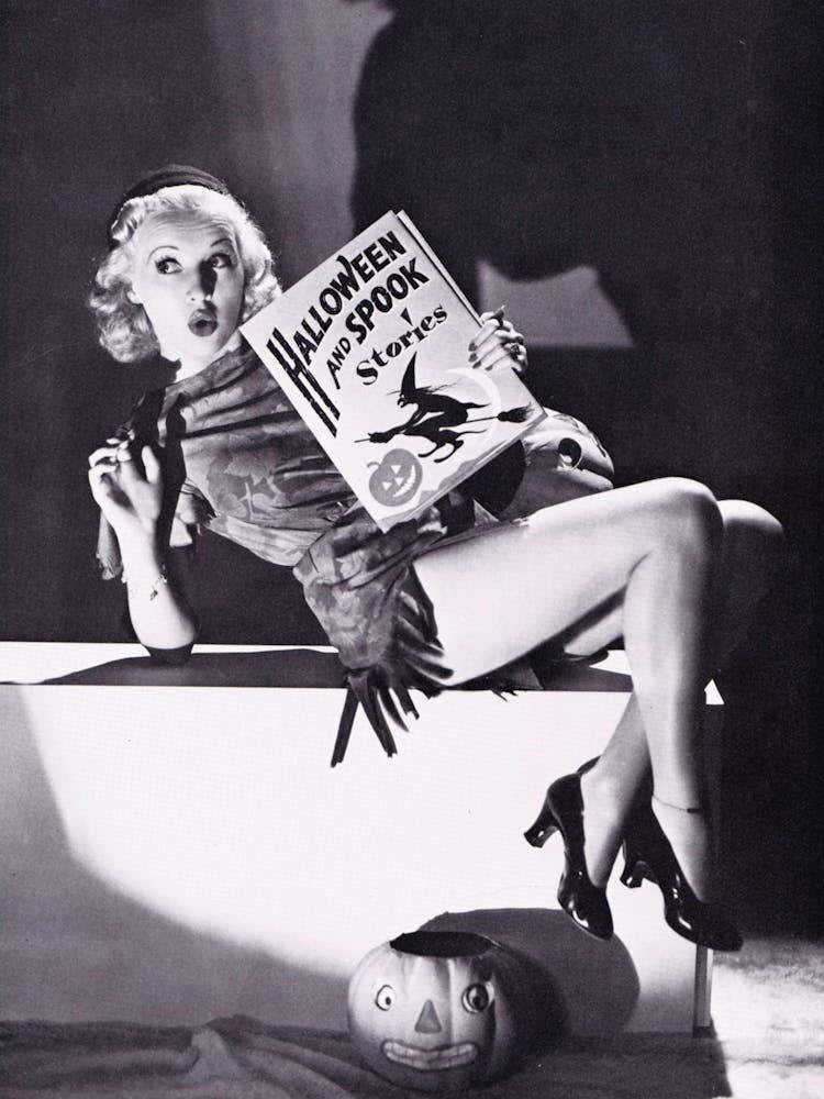 Pin Up Girl Posing With Halloween Spooky Book