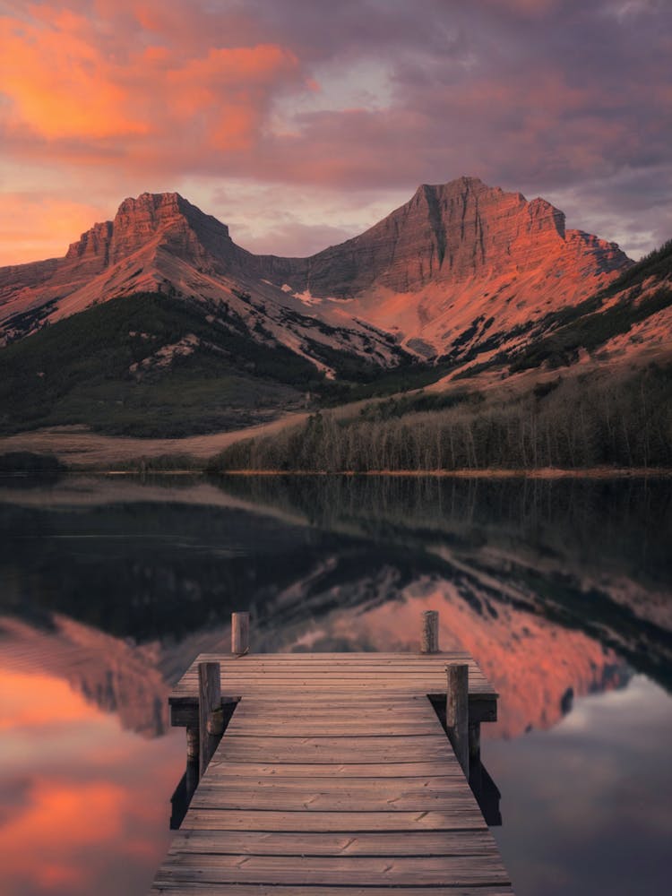 Serenity at Dusk A serene scene of a mountain landscape at sunset, with a wooden pier stretching over a tranquil lake and the warm glow of the sky reflected in the water.
Ideal for a bedroom or study, bringing a sense of peace and inspiration.