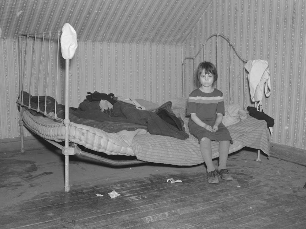 One Of Edgar Allen S Children Sitting On The Bed In The House On His Farm, There Are No Sheets, Pillowcases, Or Pillows