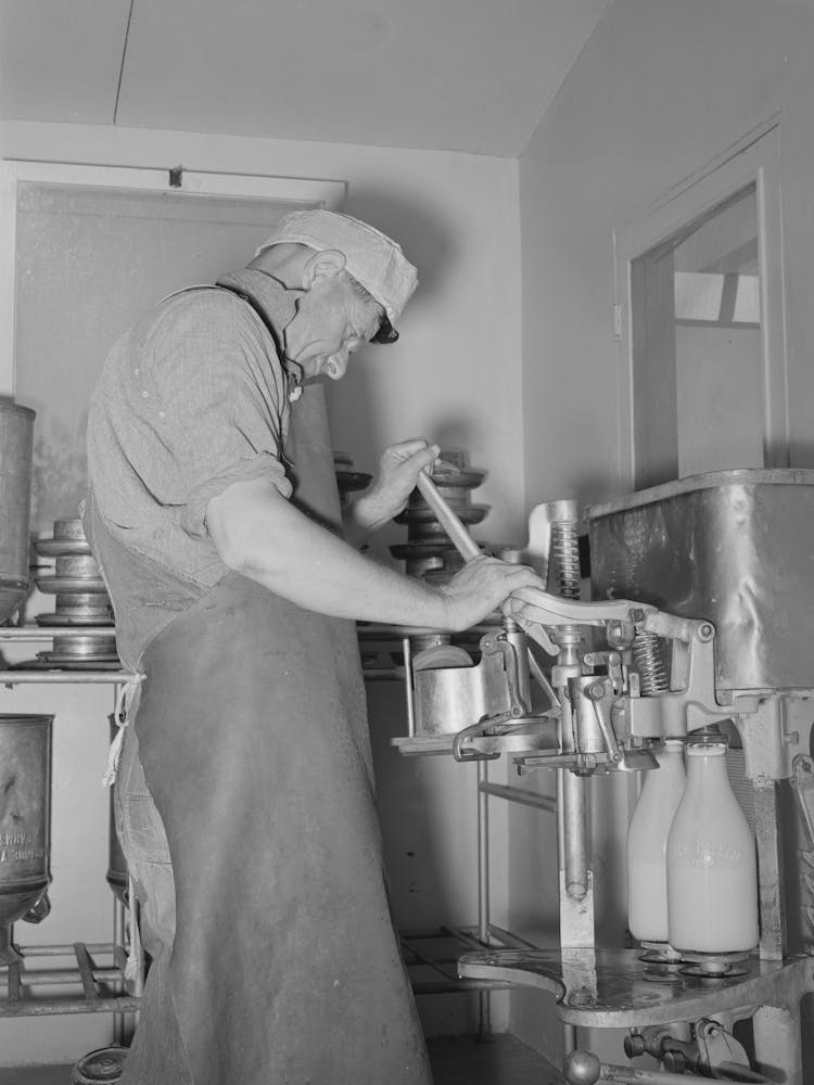 Member Of The Casa Grande Valley Farms, Arizona, Capping Milk Bottles By Russell Lee