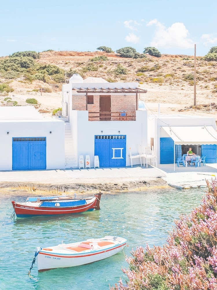Milos, Greece I Cyclades blue and white fishing village architecture with Bougainvillea pink flowers wild boho nature photography and colorful boats in paradise blue turquoise waters of the Mediterranean sea